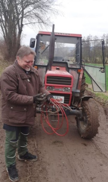 Tomas mit Traktor. Er hat den Bus aus dem Schlamm gezogen.